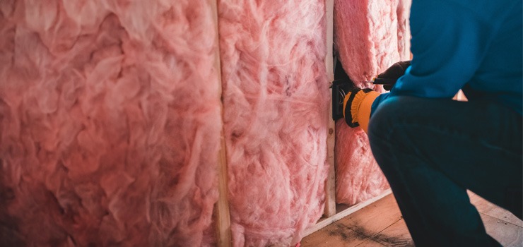 A person indulating a property to save on carbon emissions