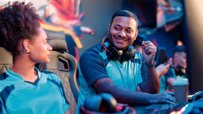 Two esports students, a man and a woman, chat between games