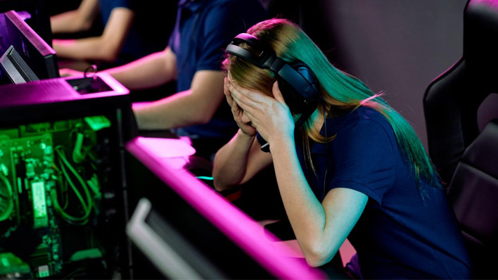 Young esports gamer sits with her head in her hands after losing a match