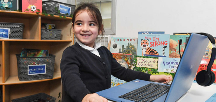 A child learning to read using a laptop