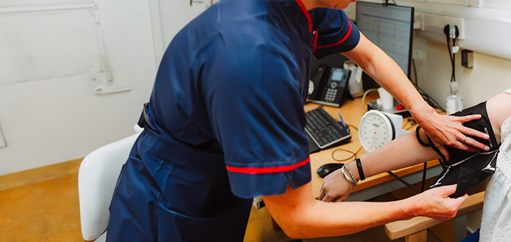 A nurse taking someones blood pressure