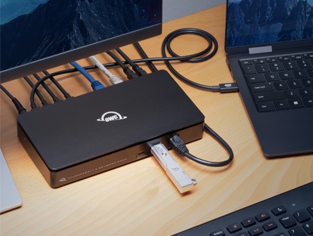 A docking station from OWC with multiple devices and cables plugged into it