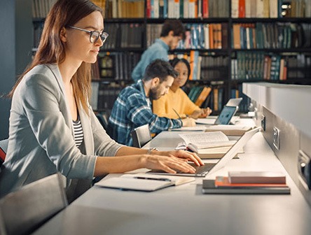 A student in a library learning at a computer