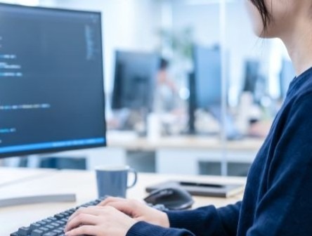 A person working on a computer connected to a cloud network