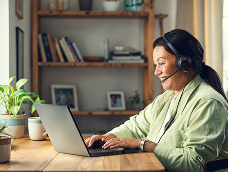 A woman wearing an EPOS IMPACT Line headset at work