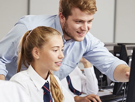 A student and teacher at a computer