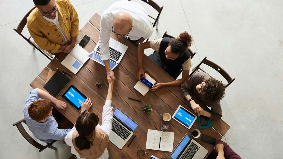 A group of people around a table using laptops