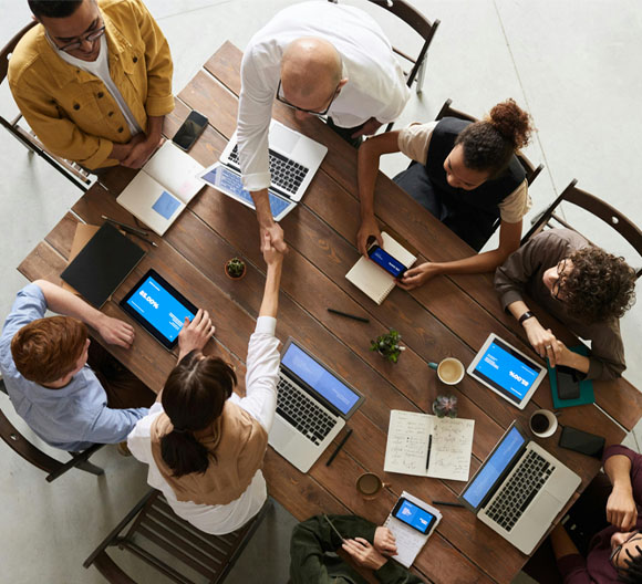 A group of people around a table using laptops