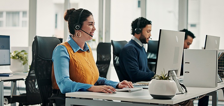 A woman at a desk working on a sustainable computer