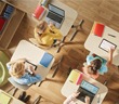 People around a desk at school using IT equipment connected through Converge
